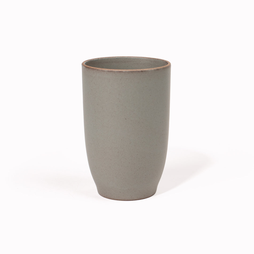 The 350ml Grey Nori Porcelain Tumbler is a Japanese manufactured tall grey tea, coffee or juice cup from Kinto.  The porcelain has a tactile sloping side and smooth finish which feels pleasing in your hands. The glaze is a tasteful matt grey stone with raw porcelain edges in the Japanese style. 