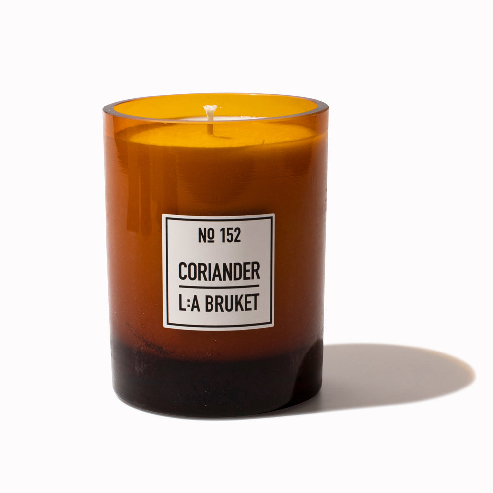 Coriander Large scented candle with lid off from L:A Bruket. Refillable scented candle from L:A Bruket, made of wax from organic soy with a burn time of more than 45 hours. Notes of fresh coriander and mint leaves. A bestselling soy candle both online and in-store, this is a delicious fragrance from the Swedish self-care brand.