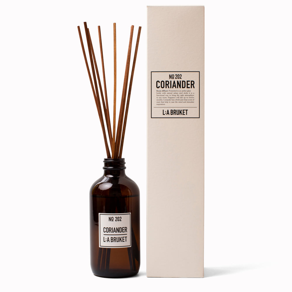 Coriander Reed Diffuser 202 with box from L:A Bruket. Room diffuser with a fresh scent of coriander and mint leaves, presented in an amber glass bottle with natural rattan reed sticks. The scent is made from a natural vegetable based solubiliser derived from renewable sources.