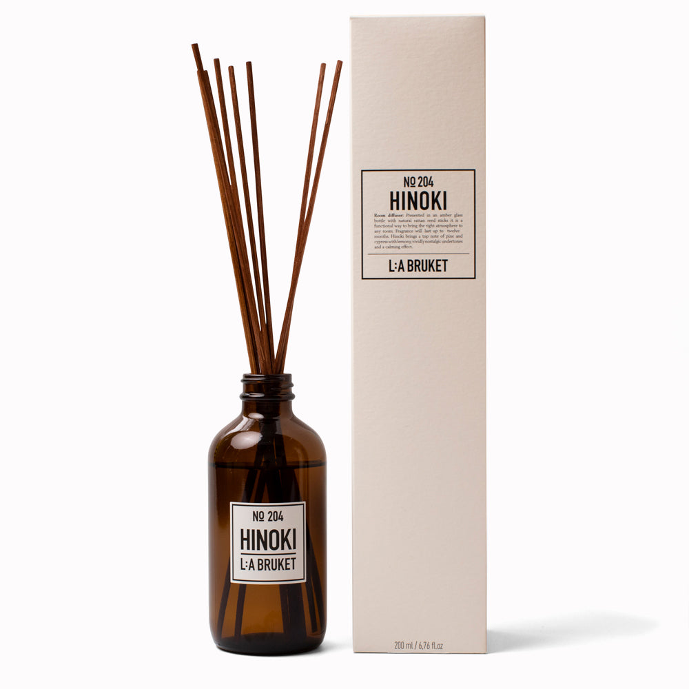 Hinoki Reed Diffuser 204 with Box from L:A Bruket. Room diffuser with a fresh scent of Hinoki, a woody outdoor scent of Japanese cypress, cedar wood and nutmeg. It is presented in an amber glass bottle with natural rattan reed sticks with the scent made from a natural vegetable based solubiliser derived from renewable sources.