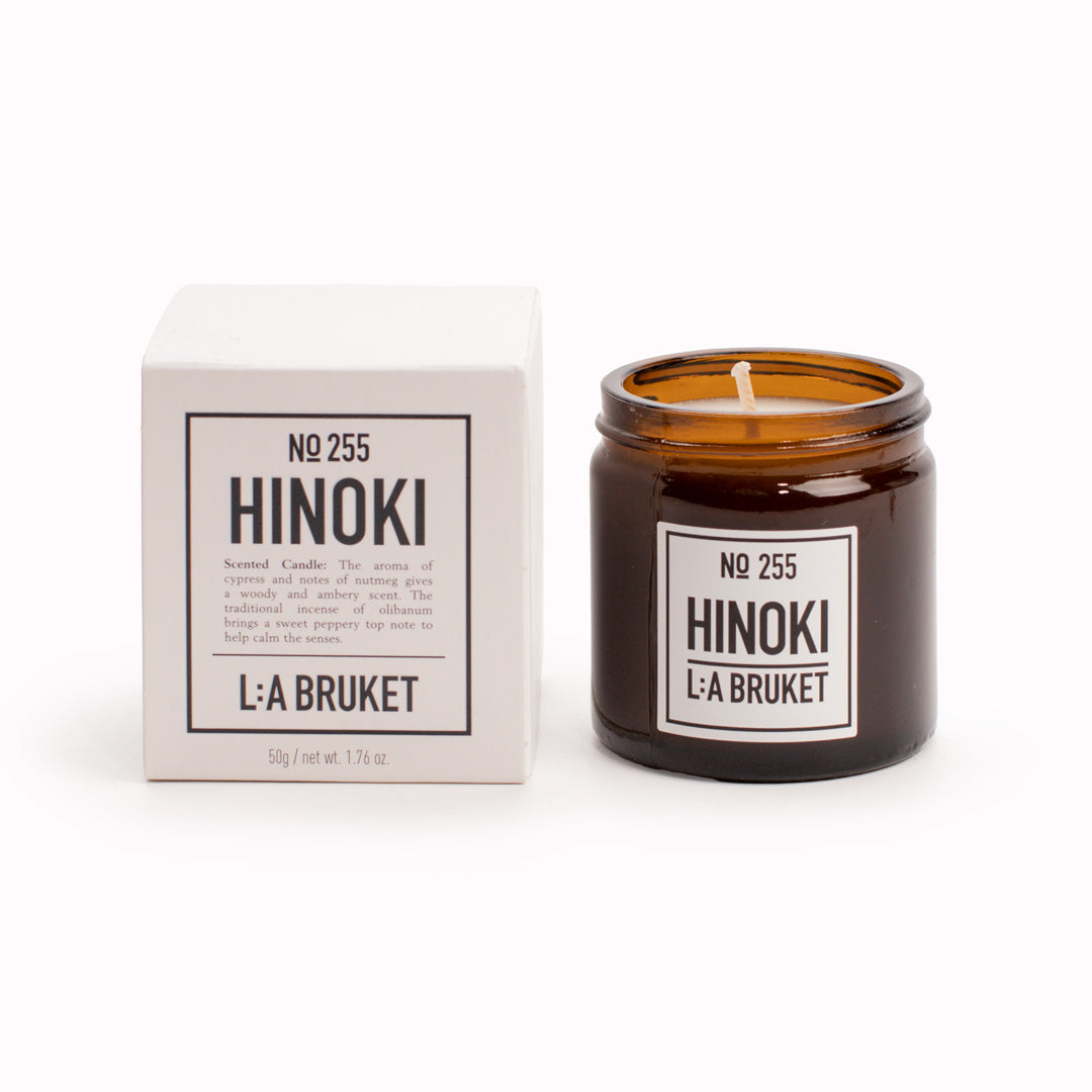 Hinoki Travel Sized Scented Candle with Box from L:A Bruket. Hinoki scented travel candle from L:A Bruket, made of wax from organic soy with a burn time of more than 15 hours. The candle is filled by hand in a mouth-blown amber tinted glass.