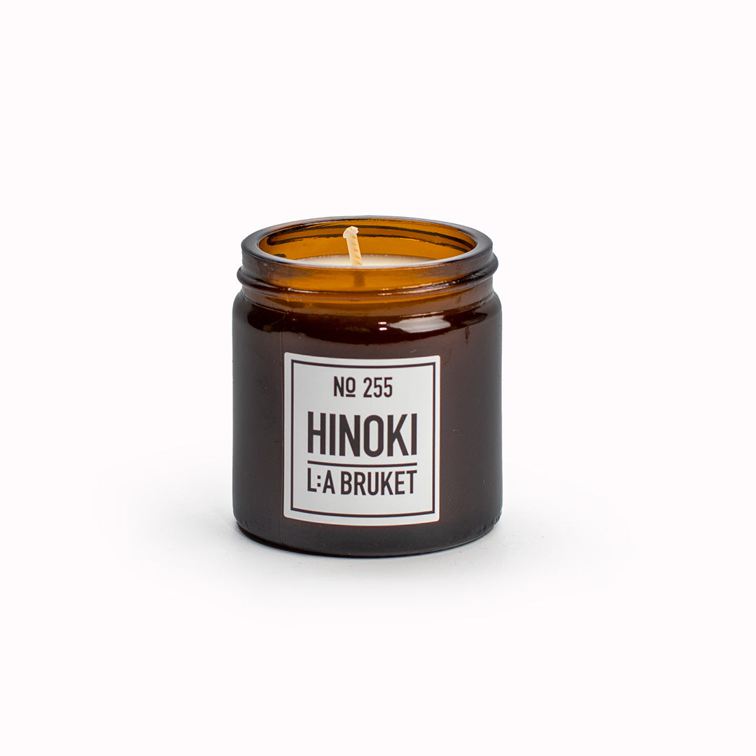 Hinoki scented travel candle from L:A Bruket, made of wax from organic soy with a burn time of more than 15 hours. The candle is filled by hand in a mouth-blown amber tinted glass.