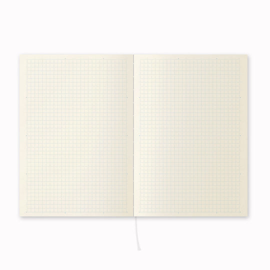 Open notebook, showing grid layout. A5 grid paper notebook with a simple and clean off white cover and embossed MD Paper logo. MD-Paper epitomises the subtlety, elegance and simplicity of design of good Japanese stationery, concentrating on the quality of material over branding or printed design. This 176 page notebook features a grid ruled layout and lay-flat binding, with a paraffin paper cover for a touch of elegance.