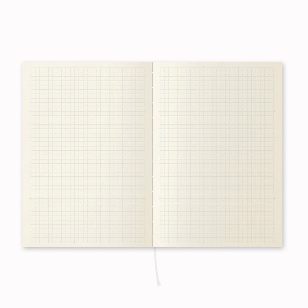 Open notebook, showing grid layout. A5 grid paper notebook with a simple and clean off white cover and embossed MD Paper logo. MD-Paper epitomises the subtlety, elegance and simplicity of design of good Japanese stationery, concentrating on the quality of material over branding or printed design. This 176 page notebook features a grid ruled layout and lay-flat binding, with a paraffin paper cover for a touch of elegance.