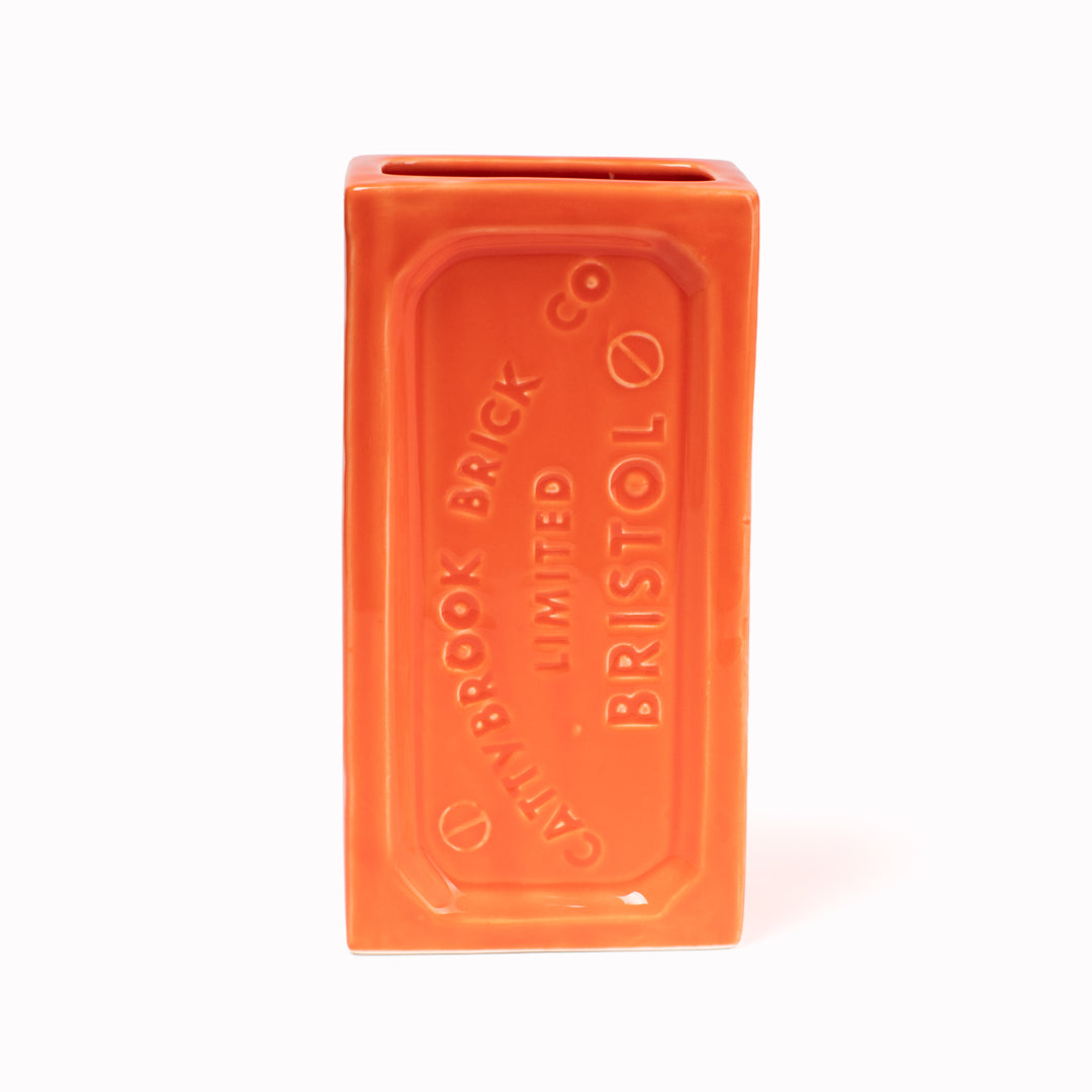 A ceramic vase in the shape of the classic Bristol Brick. Made by StolenForm, a concept brand that specialises in repurposing industrialised objects, transforming them into home accessories and giftware products. The Bristol bricks are watertight, perfect for flowers and plants, or can be used for office stationery or kitchen utensils. This colourway is Orange.