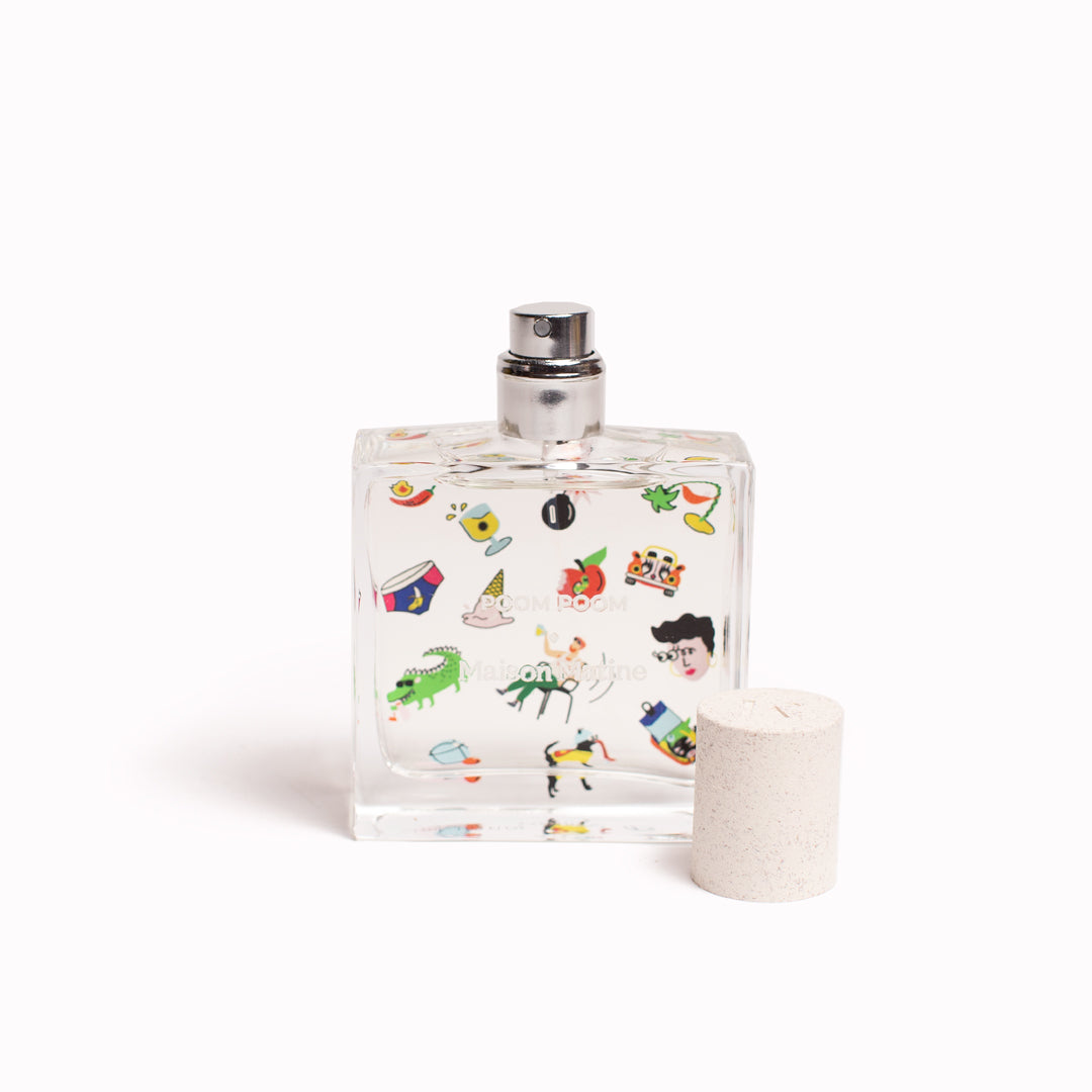 Maison Matine's 'Poom Poom' is a scent that is a carefree ode to life itself... floral, woody, musky and happy! The perfume comes in a beautiful illustrative bottle. 50ml bottle with cap off. Illustrated with cartoon-style imagery.