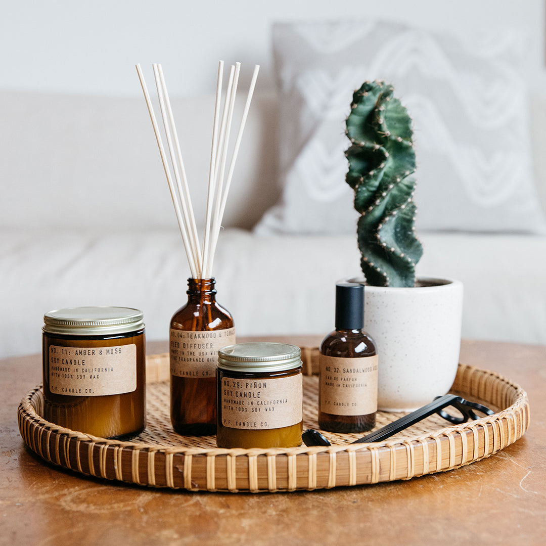 Teakwood and Tobacco Reed Diffuser from PF Candle Co in a lifestyle setting on a tray with cactus