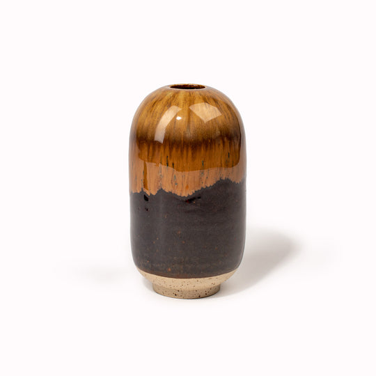 The glossy brown 'Root Beer Float' design is hand-thrown in watertight stoneware and due to the rounded taper at the top of the vase, the glaze melts down the sides of the cylindrical vase mimicking melting ice. Each piece is handmade in Denmark from the Arhoj studio in Copenhagen. This means the glaze colour and finish will never be exactly the same on any two items, and this is absolutely a part of their unique appeal.