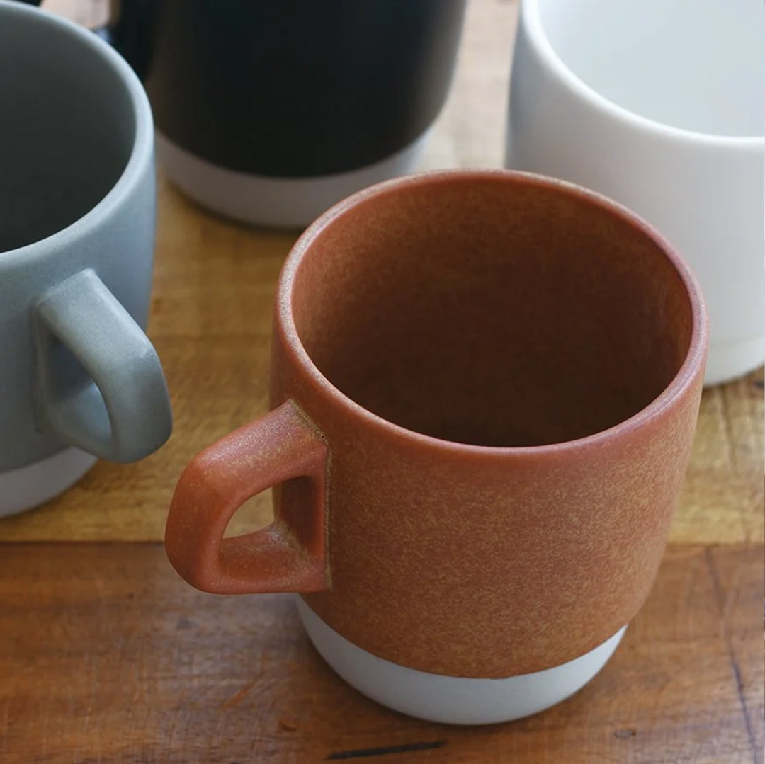 Mug Collection from Kinto - These mugs show the clay base under the matte textured glaze. Their stackability make them ideal for daily use.