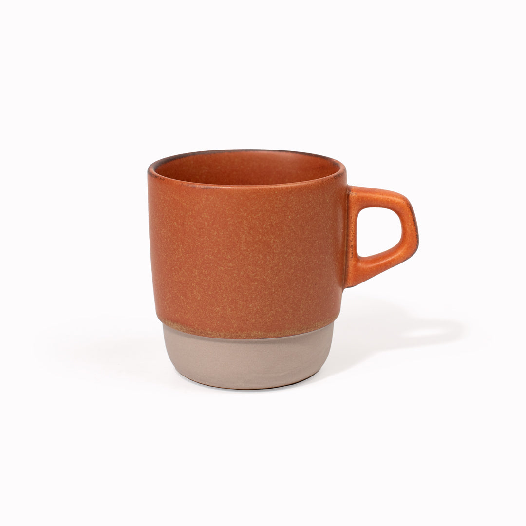 The Orange/Rust SCS stacking mug is designed to be used as a coffee cup, as part of the Kinto SCS (Slow Coffee Style) range of coffee brewing and drinking products. Made from Japanese porcelain with a two tone natural and grey glaze, this mug has a bevelled bottom, which allows it to stack neatly with other mugs in the range for storage. It holds 320ml and is microwave and dishwasher safe.