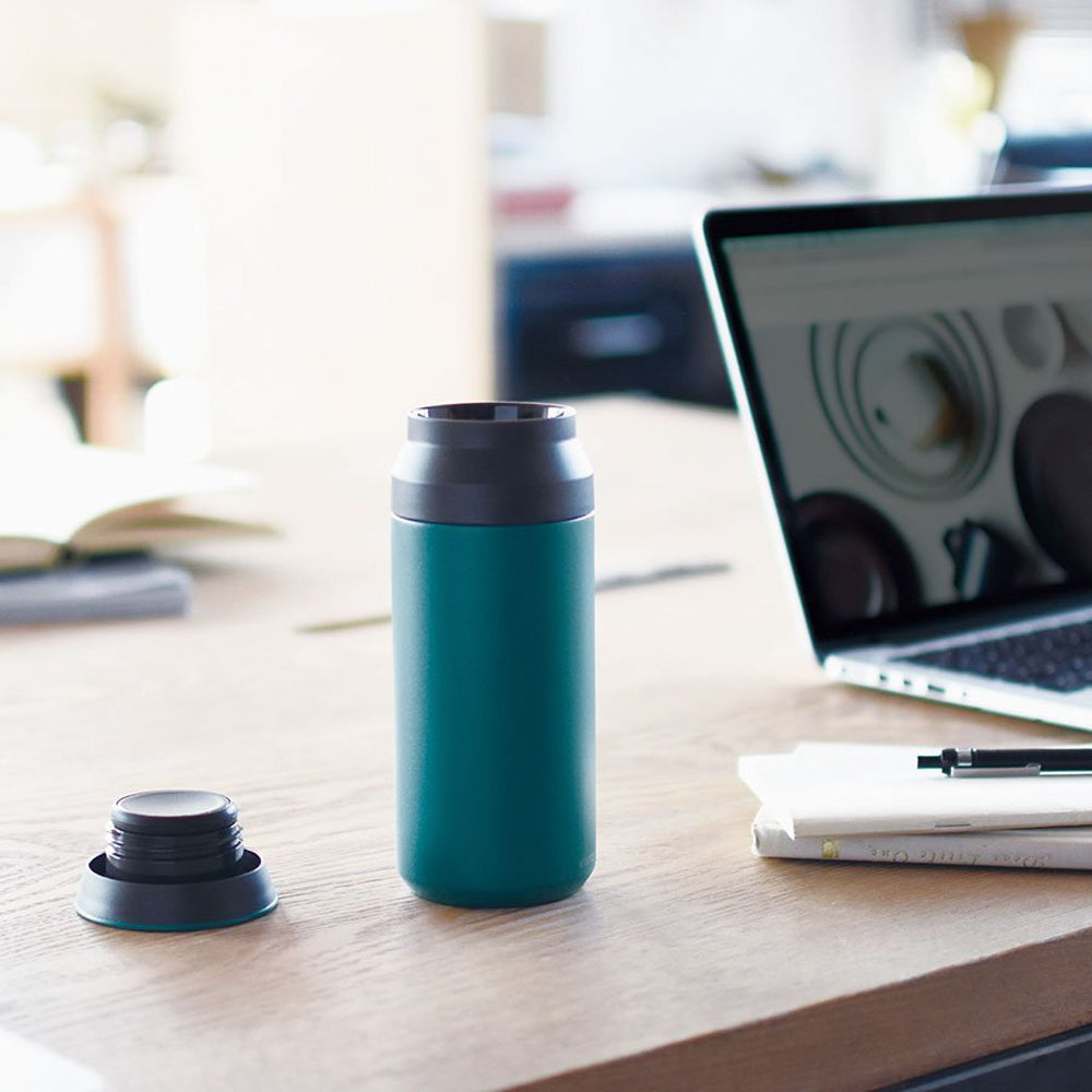 Turquoise Stainless steel double walled vacuum tumbler from Kinto on table, will keep drinks either hot or cold for up to 6 hours.