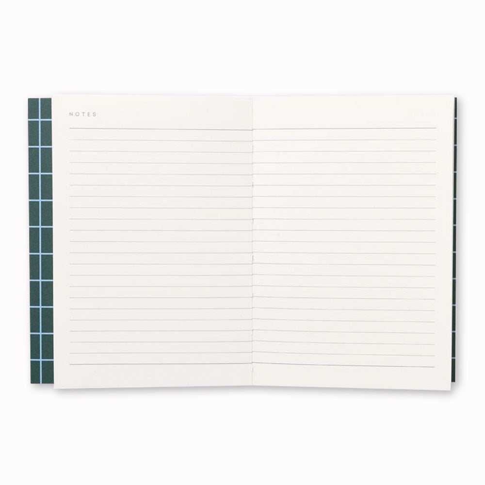 Uma Notebook, open to lined pages. The notebook also has a layflat binding that allows it to open flat on any surface, making it easy to write or sketch without any creases or bumps. 