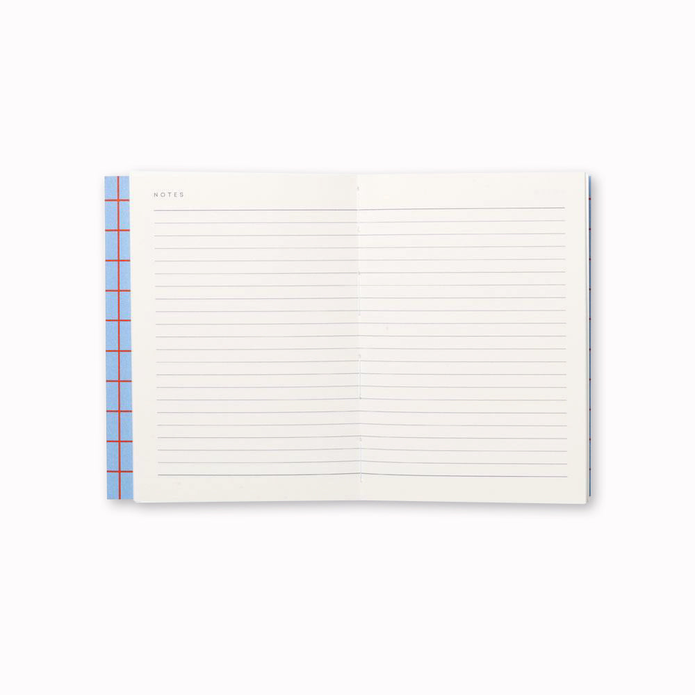 Uma Notebook, open to lined pages. The notebook also has a layflat binding that allows it to open flat on any surface, making it easy to write or sketch without any creases or bumps. 