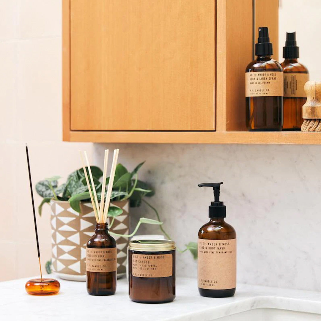PF Candle Co Amber and Moss Room and Linen Spray. Supplied in apothecary inspired amber glass bottles with their signature kraft label, part of PFCandleCo core collection. - Lifestyle image in bathroom