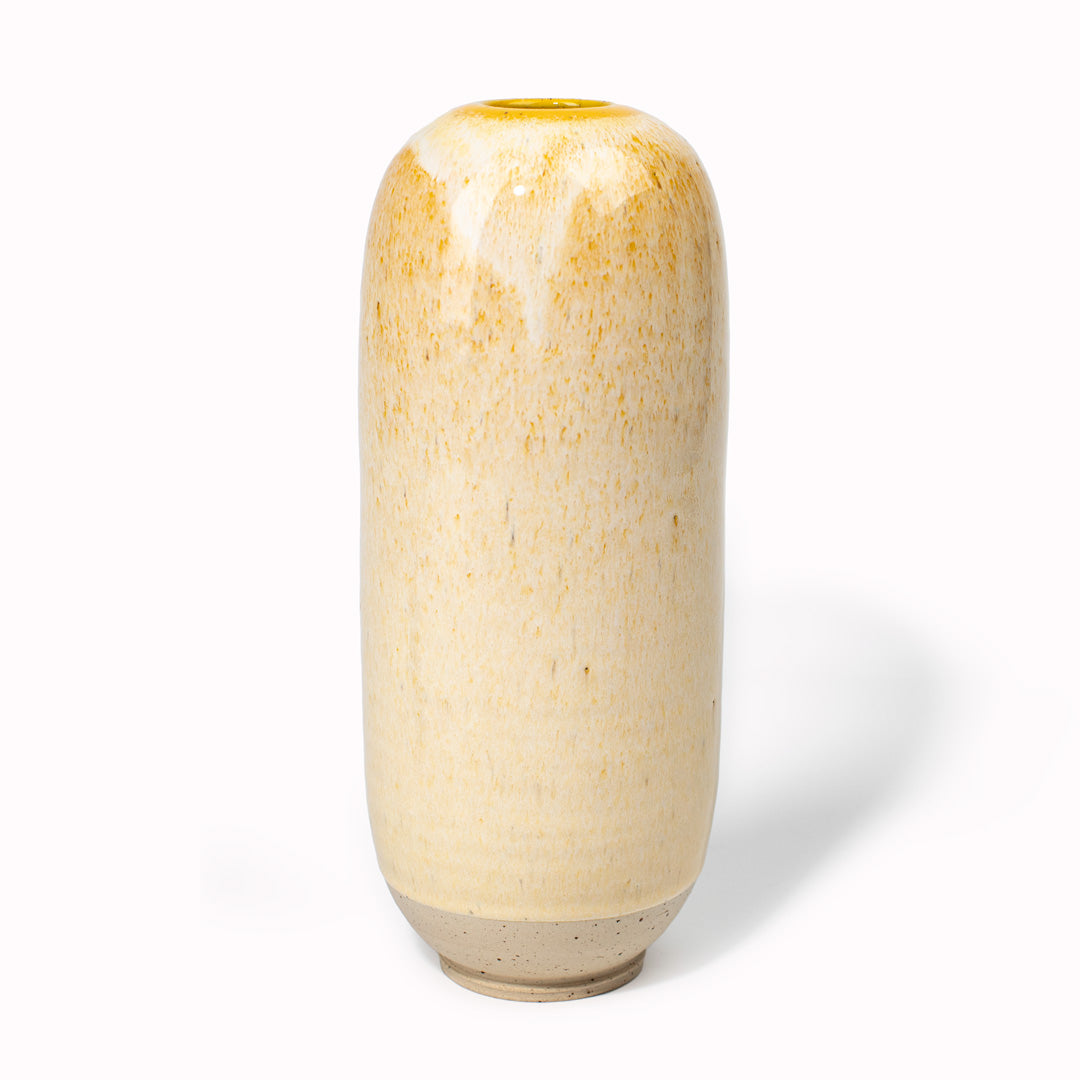 The creamy dark yellow 'Cornflower Cream' design is hand-thrown in watertight stoneware and due to the rounded taper at the top of the vase, the glaze melts down the sides of the cylindrical vase mimicking melting ice. 
