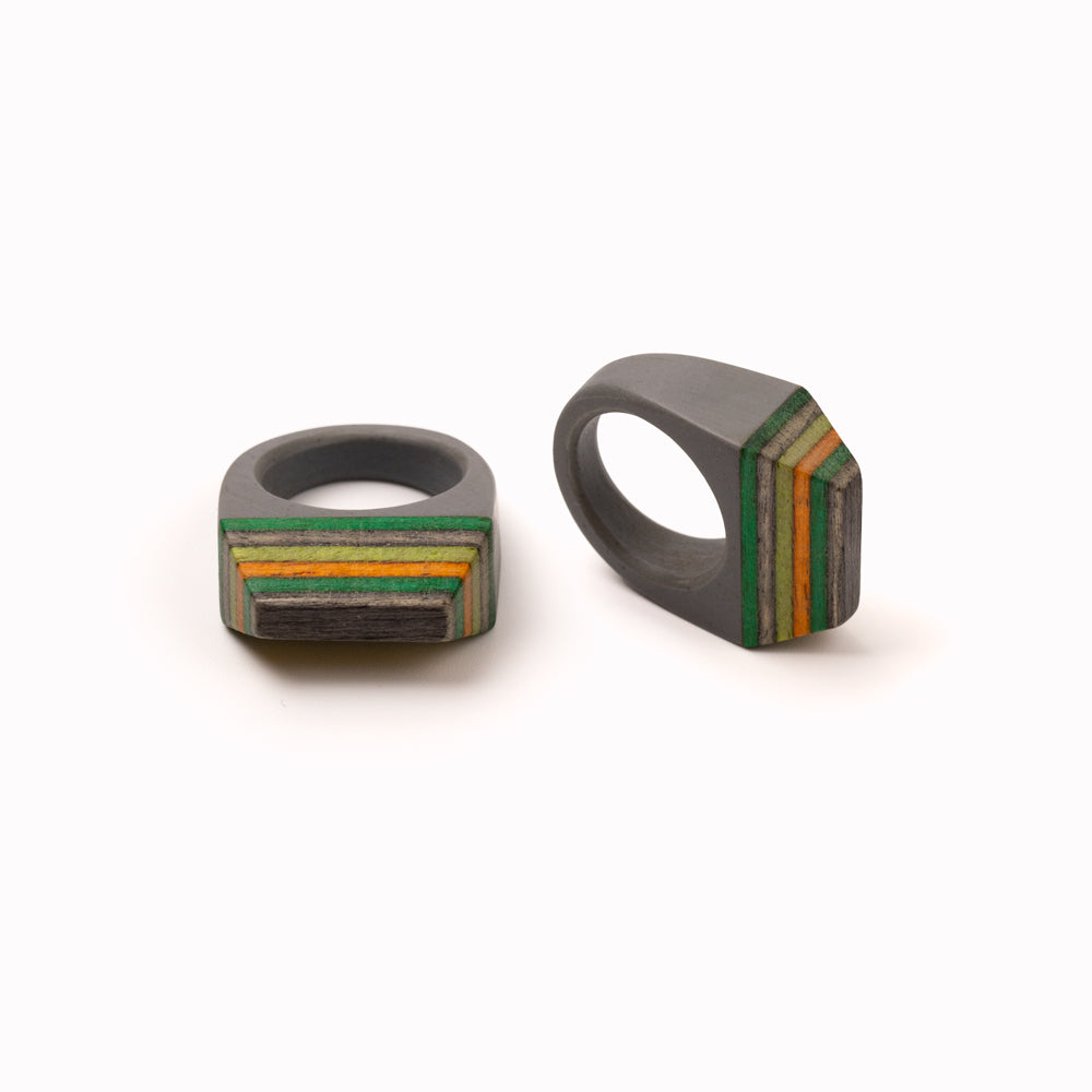 Handmade Skateboard rings by contemporary jewellery designer Simone Frabboni. The base of the ring is made of resin, the top of recycled skateboard decks. Grey statement ring with multi colour striped top