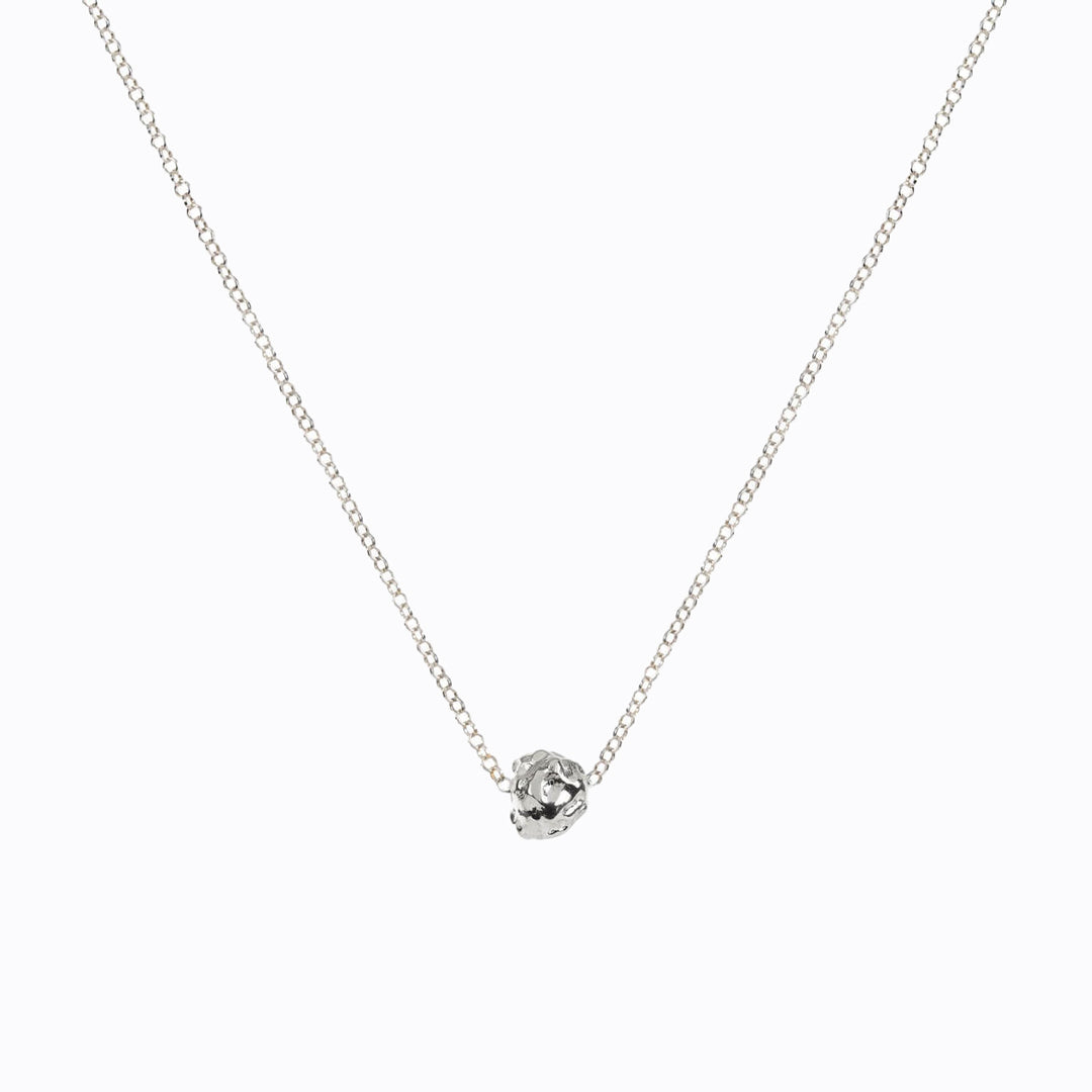 A weighty solid charm from Matthew Calvin's meteorite collection. A beautiful and delicate irregular ball pendant suspended from a sterling silver chain. Great for layering, or an elegant necklace worn alone.