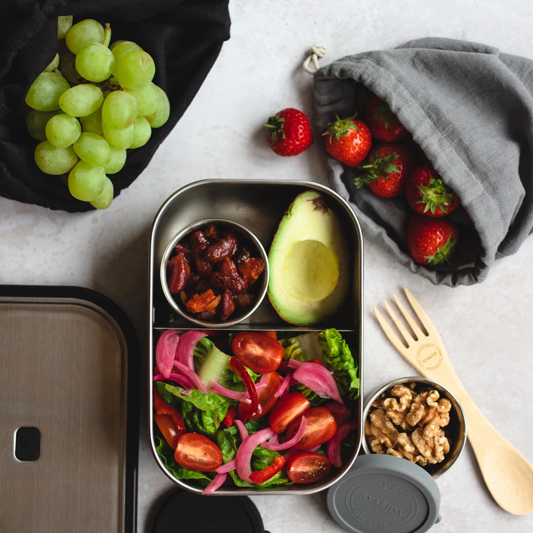 Matte Black Lunch Box by Danish brand AYA &IDA. Created from 100% food grade stainless steel, is perfect for the school bag or on the go with its adjustable divider and silicone edges making this an extremely practical lunch container. 