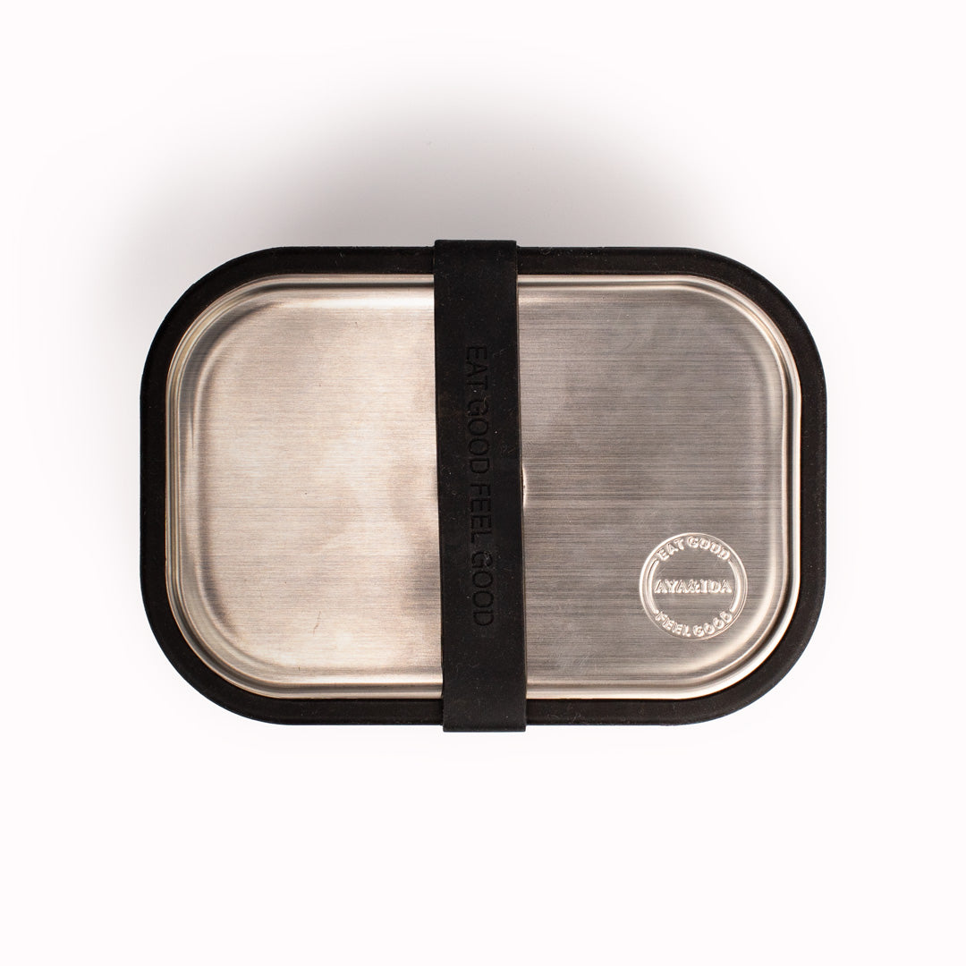 Matte Black Lunch Box by Danish brand AYA &IDA. Created from 100% food grade stainless steel, is perfect for the school bag or on the go with its adjustable divider and silicone edges making this an extremely practical lunch container.