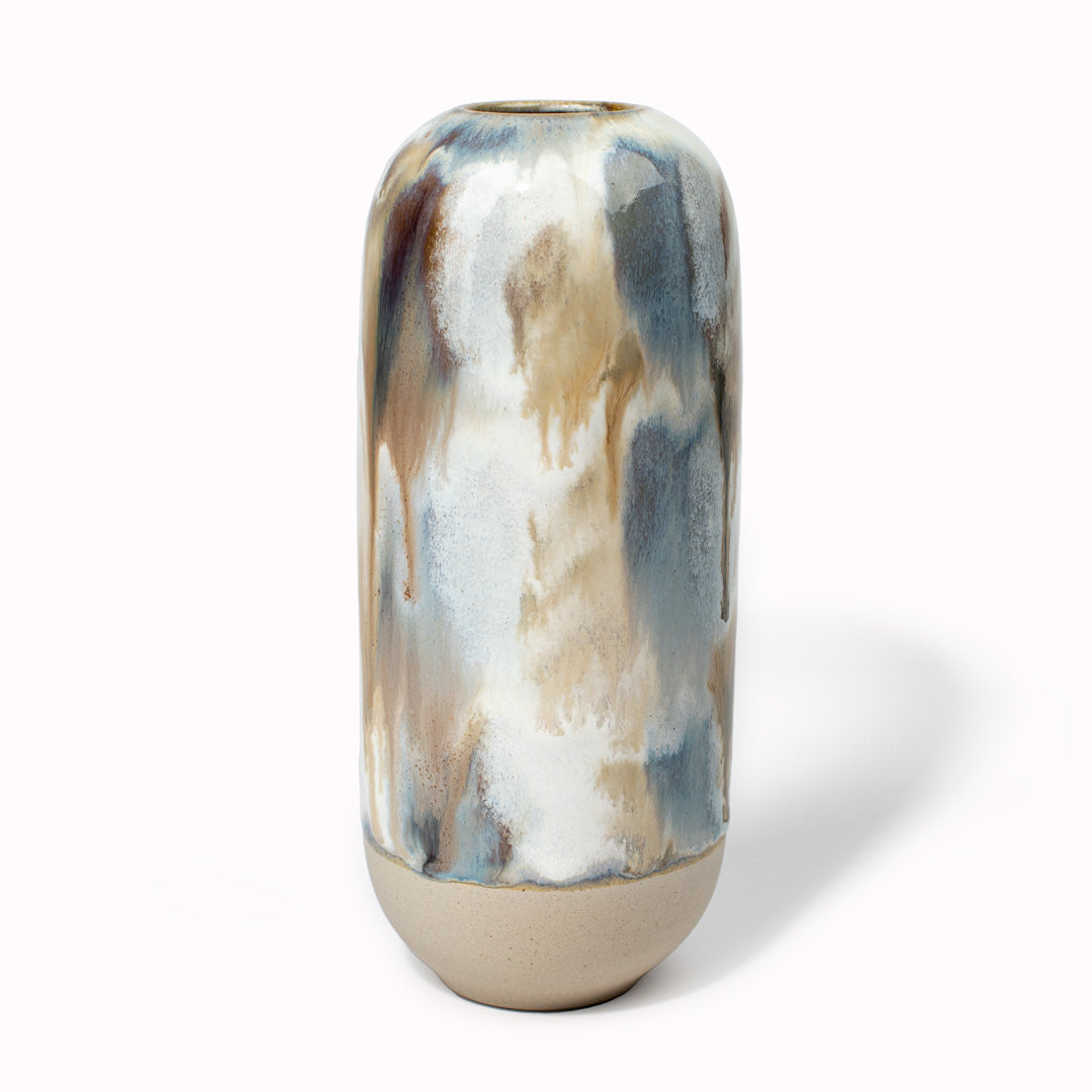 The brown, blue mottled design is hand-thrown in watertight stoneware and due to the rounded taper at the top of the vase, the glaze melts down the sides of the cylindrical vase mimicking melting ice.