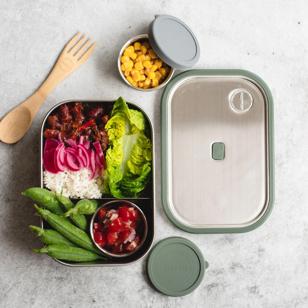 Tropical Green Lunch Box by Danish brand AYA &IDA. Created from 100% food grade stainless steel, is perfect for the school bag or on the go with its adjustable divider and silicone edges making this an extremely practical lunch container. 