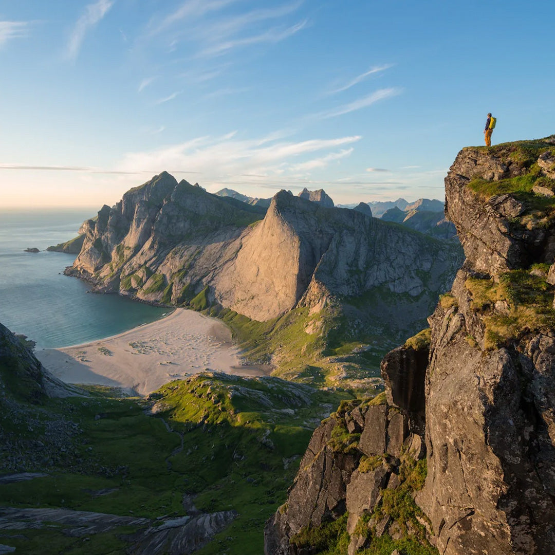 Man on cliff overlooking the ocean, example image from Wanderlust Nordics from Gestalten, From spectacular fjords in Norway, the arctic tundra and serene forests in Sweden, to a plethora of enchanting lakes in Finland and the Ice Sheet of Greenland —the Nordics offer a breath-taking variety of landscapes and endless options to hike.